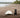 Dog on a beach next to a surf board.