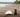 Dog on a beach next to a surf board.